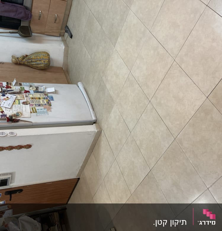 מטאטא ומגב מונחים על ארון במטבח